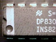 Grey part with light-grey markings S=, DP830, INS82 and a light-grey vertical line that crosses a dent, but no paint inside the dent.